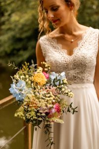 Photo, robe de mariée bohème avec son bouquet de fleur